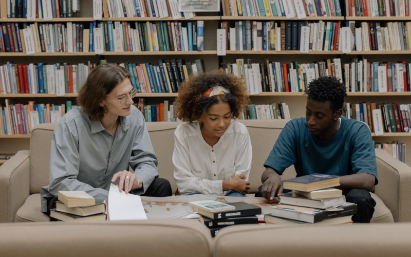 Drie studenten met studieboeken.